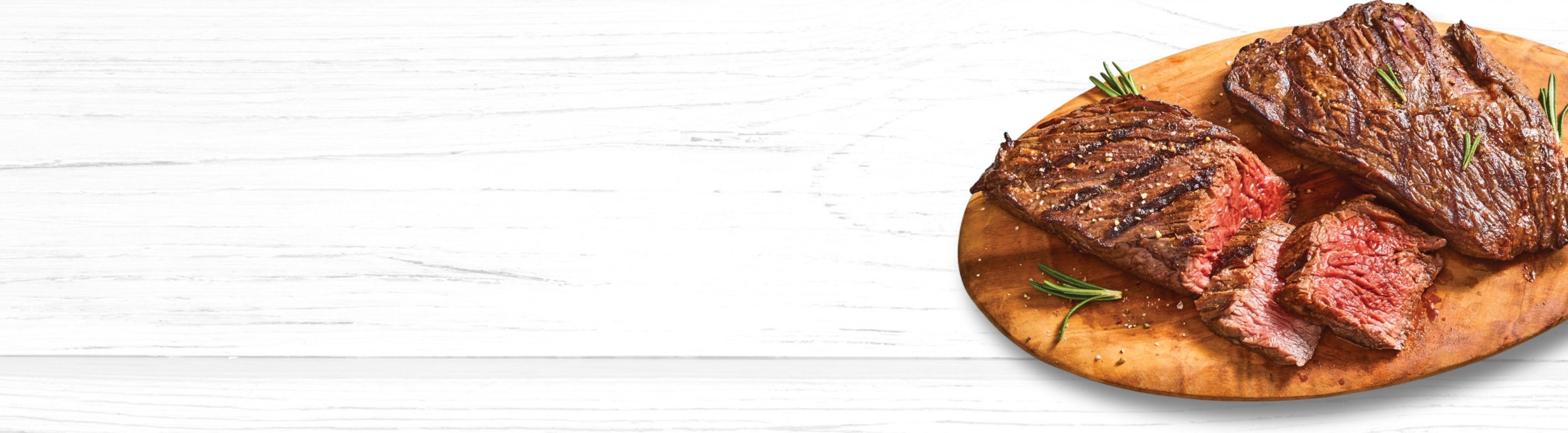 A Bavette Steak on a wooden serving board